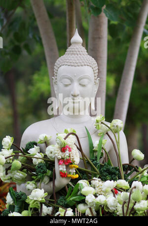 Il buddismo il culto con offrendo fiori e garland alla statua del Buddha su Magha Puja, Asalha Puja e Visakha Puja giorno in Thailandia Foto Stock