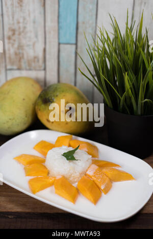 Mango riso appiccicoso o Khaoniao mamuang con mango fresco su una tavola di legno, un tradizionale Thai dessert fatti con riso glutinoso,mango fresco e noce di cocco Foto Stock