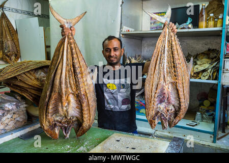 Uomo di vendere un enorme pesce essiccati, Jemenite mercato, Jeddah, Arabia Saudita, Medio Oriente Foto Stock