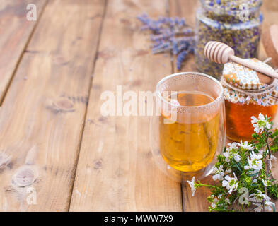 Il tè alle erbe, lavanda e miele su uno sfondo di legno. La salute naturale. Spazio libero per il testo. Spazio di copia Foto Stock