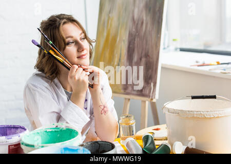 Giovane ragazza artistica che guarda lontano in studio di luce Foto Stock