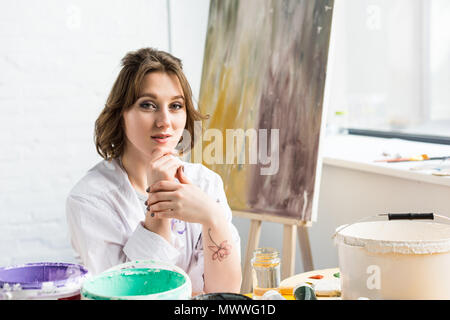 I giovani creativi ragazza con mano sul mento in studio di luce Foto Stock