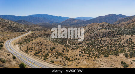 Panorama del vasto deserto deserto e della curvatura autostrada strada attraverso il vuoto. Foto Stock