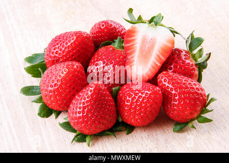 In prossimità di una fragola tagliata su una pila di prodotti freschi fragole mature Foto Stock