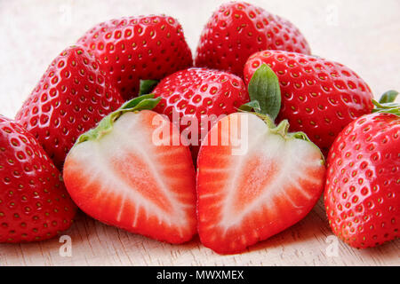 In prossimità di una fragola tagliata su una pila di prodotti freschi fragole mature Foto Stock