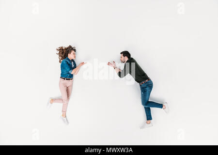 Vista superiore della donna gettando soffiata bacio al ragazzo isolato su bianco Foto Stock