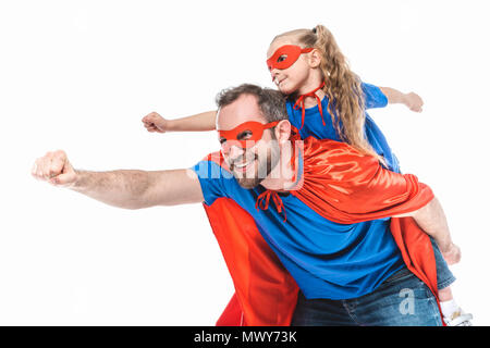 Felice padre e figlia in costumi di supereroi fingendo di volare isolato su bianco Foto Stock