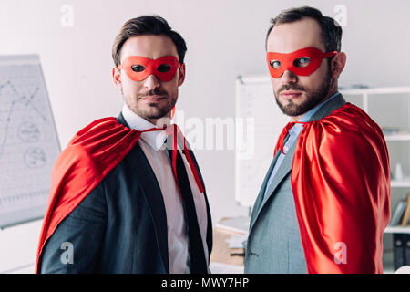 Ritratto di bello super imprenditori in maschere e mantelli in office Foto Stock