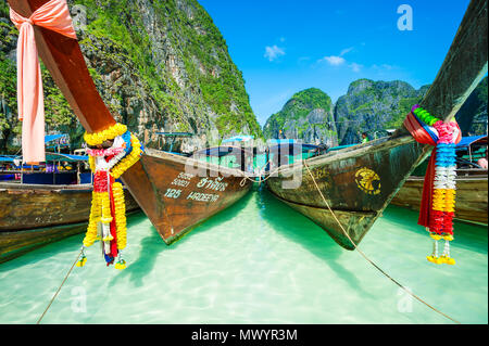 MAYA BAY, Tailandia - 12 novembre 2014: Thai longtail barche decorate con buona fortuna infissi a Maya Bay prima che essa si chiuda a causa del sovraffollamento Foto Stock