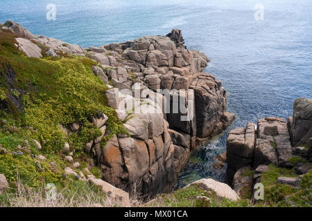 La costa rocciosa a Porthcurno, Cornwall, Inghilterra, Regno Unito, mostrando le scogliere e il mare. Foto Stock