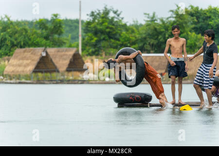 Uttaradit, Tailandia - 6 Agosto 2017: un gruppo di ragazzi adolescenti immersioni in acqua nel fiume vicino al resort in zone rurali di Uttaradit, Thailandia Foto Stock