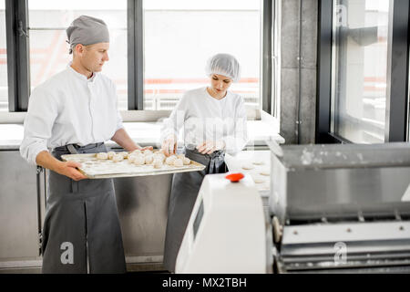 Bakers pasta di rotolamento a livello di fabbricazione Foto Stock