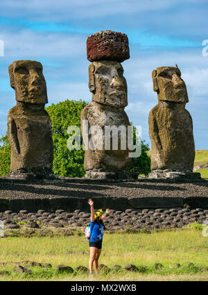 Tongariki Moai, ricostruita più grande Ahu sito archeologico, con rosso scouria topknot e la donna che posano per una foto, l'isola di pasqua, Rapa Nui, Cile Foto Stock