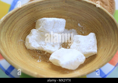 Cubi Loukoum coperti in bianco powedered zucchero in un piatto di legno. Foto Stock