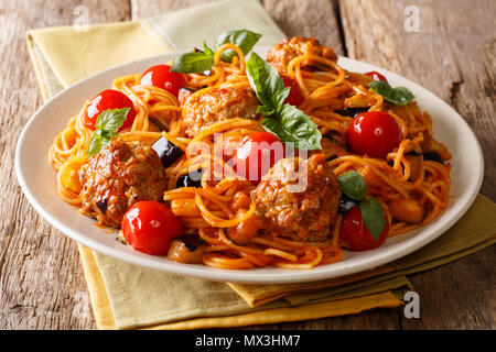 La deliziosa cena: polpette di carne con pasta di spaghetti, la melanzana e il pomodoro close-up su una piastra su un piano orizzontale. Foto Stock