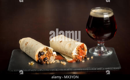 Burrito tagliati a metà e surved in un negozio di alimentari con una birra Foto Stock