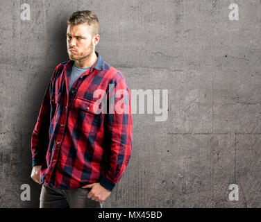 Giovane uomo bello irritato e arrabbiato esprimendo emozione negativa, arrabbiato con qualcuno Foto Stock