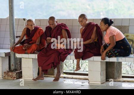 I monaci buddisti utilizzando i telefoni intelligenti, il Monte Popa vicino a Bagan, Myanmar Foto Stock