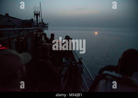 Golfo Arabico (29 aprile 2017) Comandante, USS Mare delle Filippine (CG 58), Cap. Giovanni Schmidt oltremare durante le operazioni di un uomo in mare seminatrice sul bordo guidato-missili cruiser. Mare delle Filippine è distribuito negli Stati Uniti Quinta Flotta area di operazioni a sostegno della sicurezza marittima operazioni destinate a rassicurare gli alleati e partner e preservare la libertà di navigazione e il libero flusso di commercio nella regione. (US Navy la comunicazione di massa specialista in seconda classe Patrick Ian Crimmins/rilasciato) Foto Stock