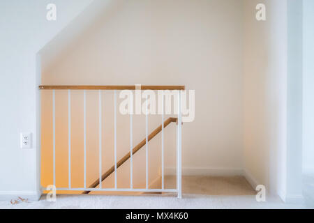 All'interno di casa home interni, townhouse con scale, passaggi o una scala conduce in basso al livello del seminterrato con luce gialla lampada incandescente, ringhiera Foto Stock