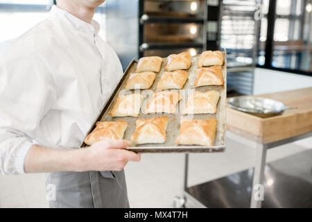 Tenendo il vassoio con pane appena sfornato panini Foto Stock