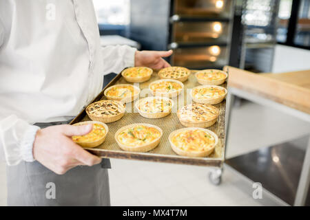 Tenendo il vassoio con pane appena sfornato panini Foto Stock