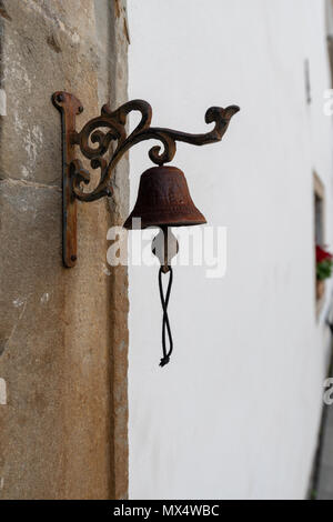 Vintage vecchia campana di metallo appendere su arco in pietra, sfondo catturato in vista frontale Foto Stock