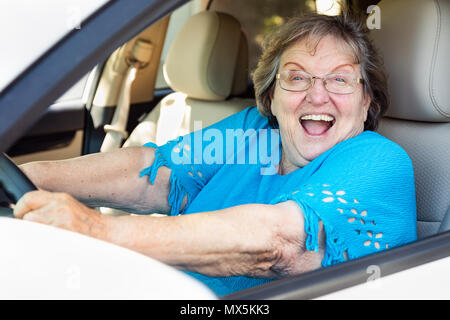 Felice Senior donna alla guida di auto nuove. Foto Stock