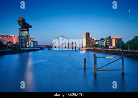 Una lunga esposizione immagine presa dal bicchiere del ponte sul fiume Clyde che mostra i famosi punti di riferimento di Glasgow, il Clyde Arc Bridge e il Finnieston gru