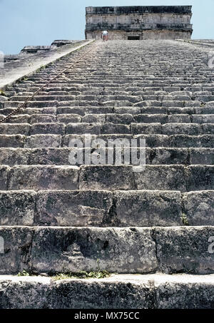 Un basso angolo di vista guardando la maggior parte dei 91 ripidi passaggi di calcare che salgono verso l'alto di El Castillo (Castello), noto anche come tempio di Kukulcan, più famose rovine Maya in antico sito archeologico di Chichen Itza sulla penisola dello Yucatan in Messico. Avvicinandosi al vertice è un turista che sta salendo a 45 gradi scala di questa piramide a gradini tenendo premuto su una lunga catena di metallo per la sicurezza. Fin da quando un alpinista cadde alla sua morte nel 2006, i visitatori non sono più ammessi a salire il 99 piedi di altezza (30 metri di struttura). Il pre-Colombiano landmark è un sito Patrimonio Mondiale dell'UNESCO. Foto Stock