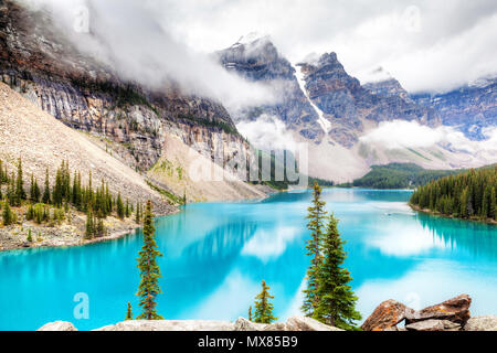 Nebbia e nuvole scendono sulla valle di dieci picchi dove alimentati da ghiacciai Lago Moraine cede il suo distinto blu turchese colore a causa della rifrazione di li Foto Stock