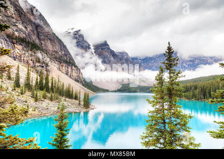 Nebbia e nuvole scendono sulla valle di dieci picchi dove alimentati da ghiacciai Lago Moraine cede il suo distinto blu turchese colore a causa della rifrazione di li Foto Stock