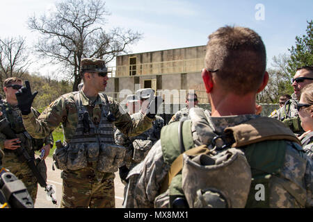 Stati Uniti Il personale dell'esercito Sgt. Kevin Graham, un ingegnere di combattimento e Observer-Coach-Trainer con il componente attivo/Riserva componente del 181st multifunzione brigata di formazione recensioni le procedure di rispondere al nemico contatto con U.S. La riserva di esercito di soldati dell'Ingegnere 341 società e 401 Engineer Company (multiruolo Bridge Company) come si riuniscono al completamento della formazione di una corsia su Fort McCoy, Wis., come parte di un guerriero esercizio 86-17-02, 3 maggio 2017. Più di 70 U.S. Esercito di unità di riserva condotta Combat training per aumentare la loro mortalità come unità coesiva di azione durante la 84T Foto Stock