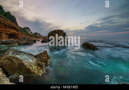 Tramonto sulla spiaggia tra le rocce vicino alla città di Denia. Distretto di Valencia, Spagna. Foto Stock