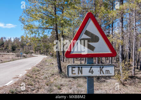 Curve pericolose in anticipo, prima a destra, in 4 Km, spagnolo segno di traffico, paese strada laterale, Spagna Foto Stock