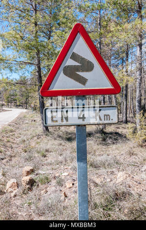 Curve pericolose in anticipo, prima a destra, in 4 Km, spagnolo segno di traffico, paese strada laterale, Spagna Foto Stock