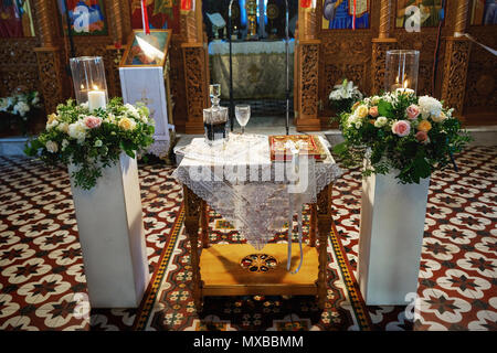 Corone di nozze, Bibbia e bicchieri da vino sono preparati per cerimonia Foto Stock