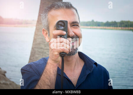 L'uomo con la vecchia fotocamera vintage in mani. Foto Stock