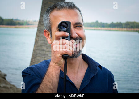 L'uomo con la vecchia fotocamera vintage in mani. Foto Stock