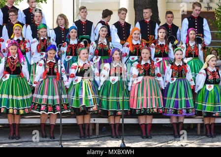 Lowicz / Polonia - maggio 31.2018: locale, regionale coro di giovani donne e uomini vestiti in costumi folcloristici. Colorato di gonne e pantaloni, camicie bianche, viv Foto Stock