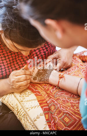 L'henna artista (Mehndi) pittura la mano delle donne che è stato ospite nel matrimonio indiano Foto Stock