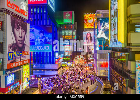 OSAKA, GIAPPONE - Agosto 16, 2015: pedoni camminare sotto i cartelloni nel quartiere Dotonbori. Il quartiere è una popolare attrazione turistica. Foto Stock