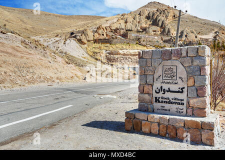 Kandovan, Est Azerbaigian provincia, Iran - Marzo 16, 2018: firmare all'entrata al villaggio rupestre Kandovan Foto Stock