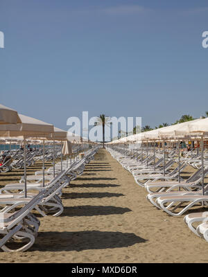Larnaca, Cipro, Makenzie beach. Vuoto di sedie a sdraio e ombrelloni sulla sabbia Foto Stock