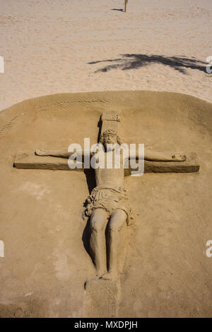 Scultura di sabbia a Guardamar del Segura sulla spiaggia mediterranea. Gesù Cristo sulla croce. Crocifissione Foto Stock