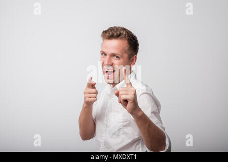 Felice uomo caucasico in piedi e sorridente. Bel maschio di metà lunghezza verticale. Foto Stock