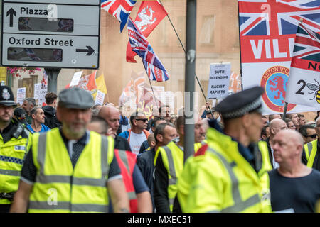 2 Giugno 2018 - Il calcio democratico Lads Alliance (DFLA) e libera Tommy Robinson attivisti lasciate fuori un rosso/arancio luce parassita durante il mese di marzo e di dimostrazione attraverso le strade di Manchester. Una linea di polizia li guidate intorno a un percorso attraverso strade più tranquille di Manchester. Foto Stock