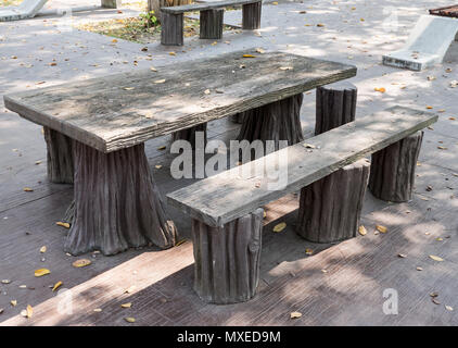 Calcestruzzo di tavolo e sedie che guarda come dal legno nel parco pubblico. Foto Stock