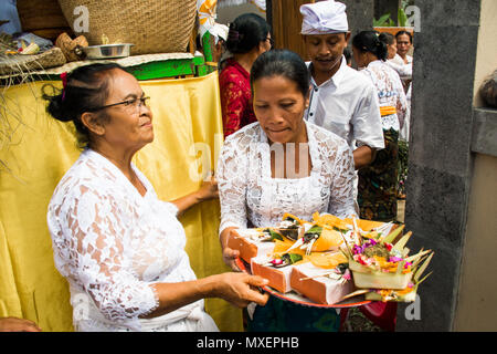 Processione di bella donna Balinese in costumi tradizionali - sarong, trasportare offrendo su capi per cerimonia Indù. Festival delle arti, della cultura di Bali è Foto Stock