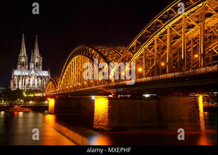 La vista sul fiume Reno con il ponte di Hohenzollern e la Cattedrale di notte è uno dei più suggestivi panorami di Colonia, Germania Foto Stock